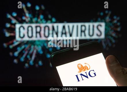 In this photo illustration the Dutch multinational banking and financial services company ING Group logo seen displayed on a smartphone with a computer model of the COVID-19 coronavirus on the background. Stock Photo