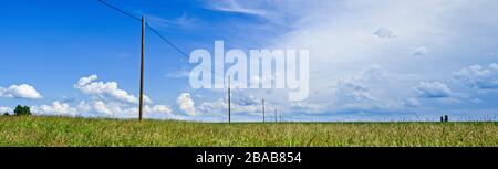 Power lines in field against cloudy sky, Baden Wurttemberg, Germany Stock Photo