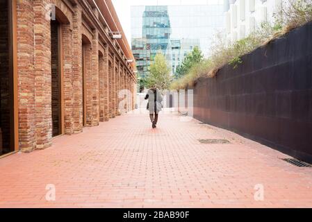 Bearded man walking across pathway holding a take away coffee Stock Photo