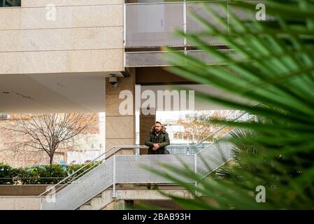 Bearded hipster man relaxing on stairs in a building complex Stock Photo