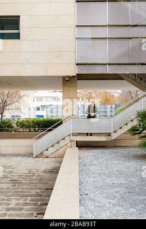 Bearded hipster man relaxing on stairs in a building complex Stock Photo