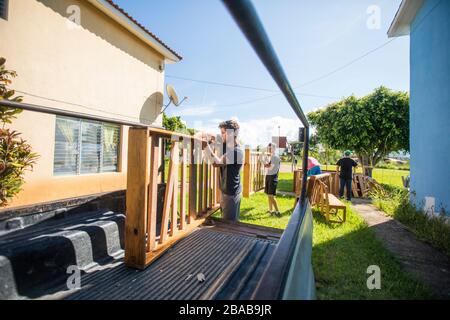 Movers load wooden furniture into back of pickup truck. Stock Photo