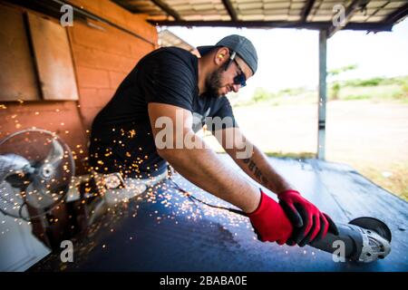 Worker using angle grinder to cut steel. Stock Photo