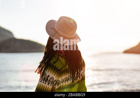 Young woman in a hat on the beach at sunset Stock Photo
