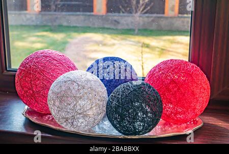 Colored balls of wound thread on a windowsill. Stock Photo