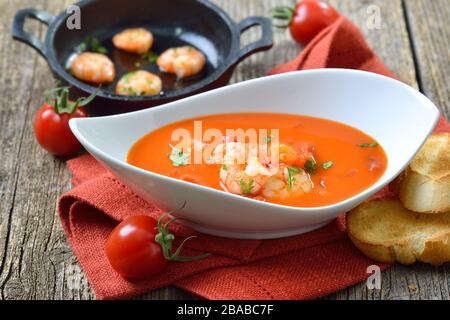 Cream of tomato soup with fried prawns, served with toasted baguette slices Stock Photo