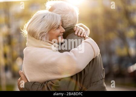 Senior couple hugging outdoors in autumn Stock Photo