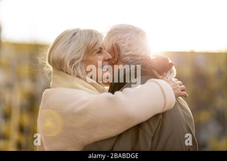 Senior couple hugging outdoors in autumn Stock Photo