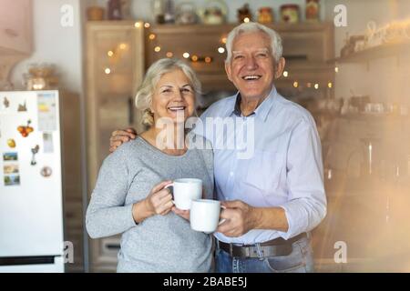 Happy senior couple embracing in their home Stock Photo