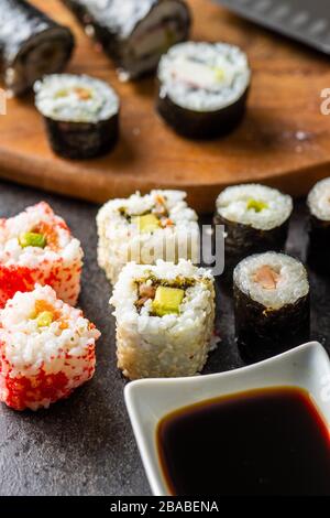 Japanese sushi food. Maki and california roll sushi with salmon, caviar, avocado, tuna and soy sauce. Stock Photo