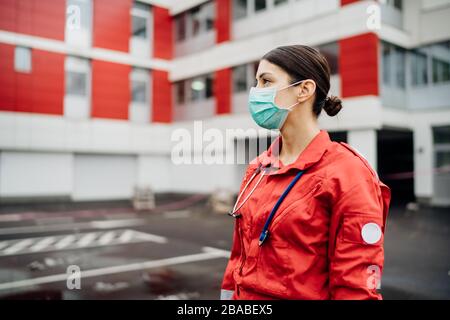 Paramedic in front of isolation hospital facility.Coronavirus Covid-19 heroes.Mental strength of medical professional.Emergency room doctor prepared Stock Photo