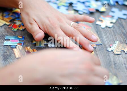 Hands on a puzzle game Stock Photo