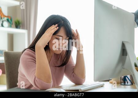 Candid of young Asian single business woman stress out with project business plan on computer laptop or notebook at home office. Asian people occupati Stock Photo