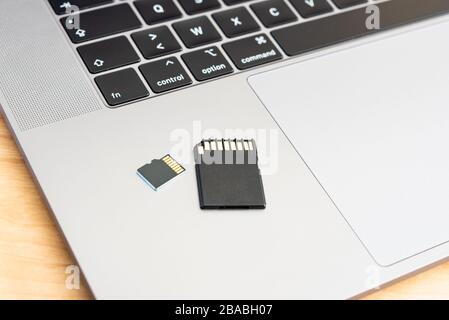 A SD and micro SD memory card on a laptop computer. Stock Photo
