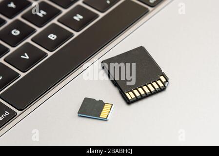A SD and micro SD memory card on a laptop computer. Stock Photo