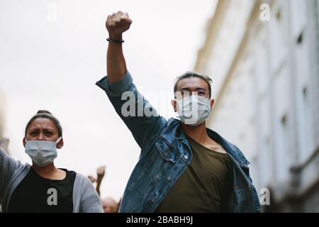 People protesting and giving slogans in a rally. Group of activists protesting against the government in the city. Stock Photo