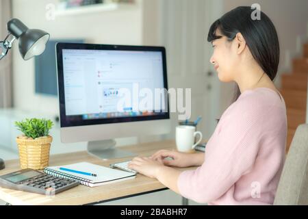 Asian business woman chatting to her colleagues about work plan in chat room. Multiethnic business team using computer for a online meeting. Group of Stock Photo
