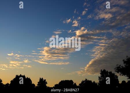 Beautiful sunsets with blue skies and clouds shot in color with natural sunlight, outside in nature on a lovely evening. Stock Photo