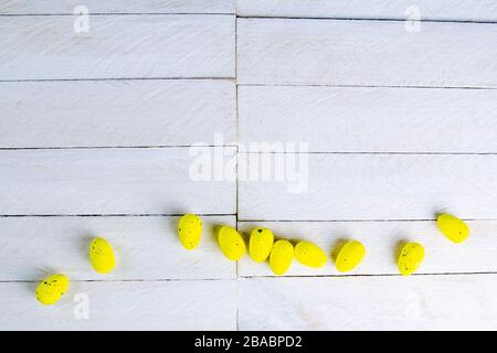 Easter concept. Yellow eggs stand on a white wooden table Stock Photo