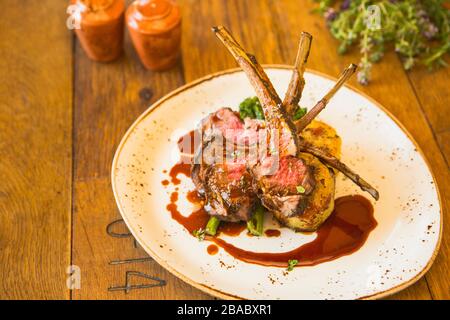 grilled Australian lamb rack with roasted sweet potatoes, charred broccolini and pomegranate demi-glace Stock Photo