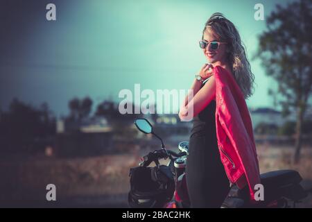 portrait of young  woman posing front classical motorbike. Stock Photo