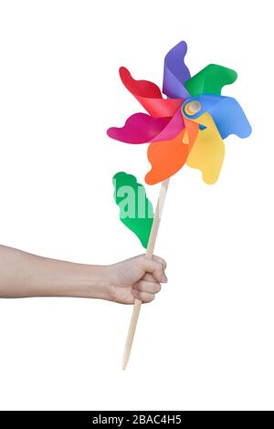 Hand holding wind turbine (Toy play) isolated on white background. Object with clipping path. Stock Photo