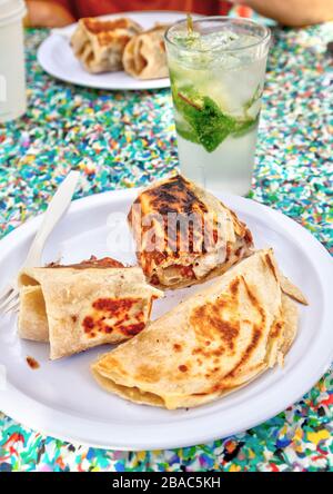 Mexican Chicken burrito in tortilla wrap and taco meal with glass of Mojito cocktail. Stock Photo