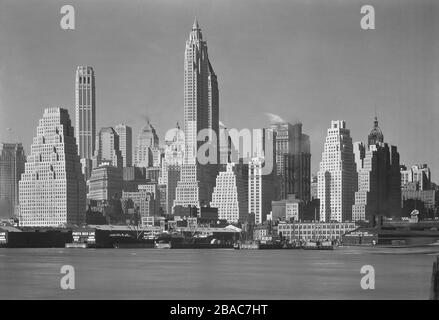 Art Deco style skyscrapers dominate Lower Manhattan's East River skyline in 1932. The four tallest buildings, L-R are: 120 Wall Street, with ziggurat profile; 20 Exchange Place built in 1930-21; 70 Pine Street, built in 1931-32; and 40 Wall Street, a 70 story tower with Neo-Gothic styling. The Singer Tower's top can barely be seen at left  (BSLOC 2018 4 69)