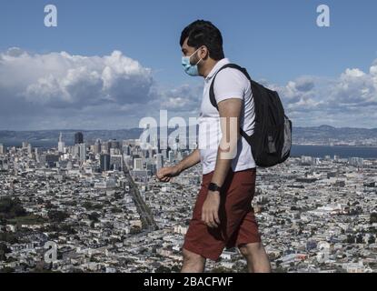 San Francisco, United States. 26th Mar, 2020. A masked man walks on Twin Peaks in San Francisco on Thursday, March 26, 2020. California is under a stay at home order except for essential needs such as grocery shopping because of the coronavirus pandemic. Photo by Terry Schmitt/UPI Credit: UPI/Alamy Live News Stock Photo