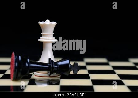 Two chessmen on chessboard, Queen defeats king, Germany Stock Photo