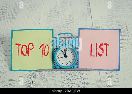 Handwriting text Top 10 List. Conceptual photo the ten most important or successful items in a particular list Mini blue alarm clock standing above bu Stock Photo