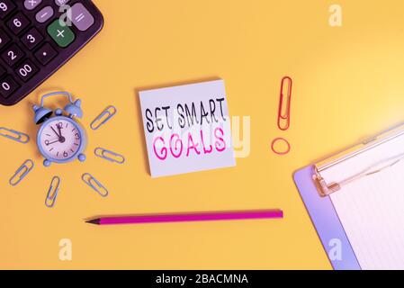 Handwriting text writing Set Smart Goals. Conceptual photo giving criteria to guide in the setting of objectives Alarm clipboard calculator clips band Stock Photo
