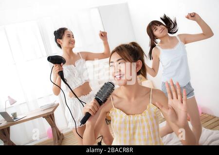 Best friend in the bedroom to play pretend to sing Stock Photo