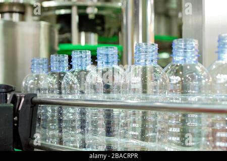 Selective focus a row of clear plastic bottles on the conveyor belt of industrial machinery, industry 4.0 Stock Photo