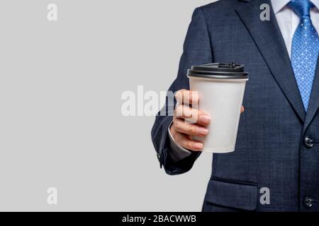 A businessman holding a white paper cup. With copy space. Stock Photo