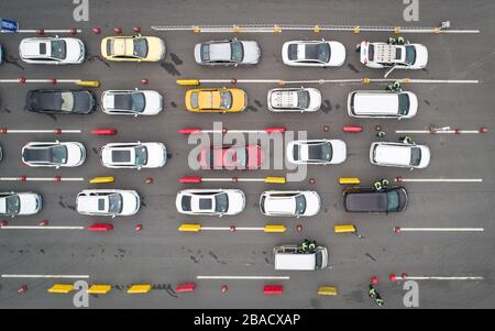 Beijing, China. 26th Mar, 2020. Aerial photo taken on March 26, 2020 shows staff on duty checking health QR code of drivers and passengers at an expressway toll-gate in Wuhan, central China's Hubei Province. Traffic flow at highway exits increased due to a growing number of people returned as Wuhan speeds up resumption of work and production. Credit: Xiao Yijiu/Xinhua/Alamy Live News Stock Photo