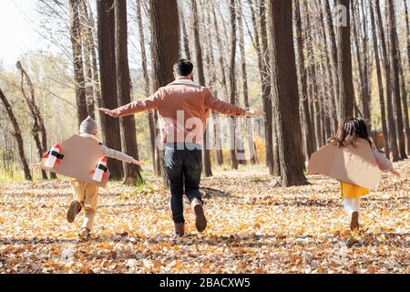 The happy children and his father in the outdoor running back Stock Photo