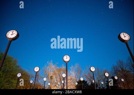 Duesseldorf, Germany. 26th Mar, 2020. The artwork 'Zeitfeld' by Klaus Rinke in the Volksgarten. The clocks point to two o'clock in the night. On 29.03. the clocks are set to summer time. Credit: Fabian Strauch/dpa/Alamy Live News Stock Photo