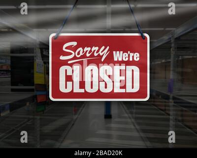 Business concept of empty store shelves with 'Sorry, We're Closed' sign. Stock Photo