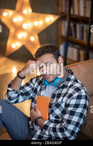 Handsome man in a checkered shirt looking thoughtful Stock Photo