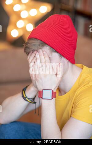Young man in a red hat sitting with his face closed Stock Photo