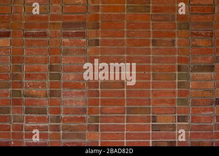 Older weathered red and brown brick wall texture background with a unique stack bond brickwork pattern. Stock Photo