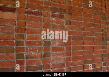 Older weathered red and brown brick wall texture background with a unique stack bond brickwork pattern. Stock Photo