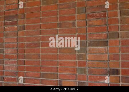 Older weathered red and brown brick wall texture background with a unique stack bond brickwork pattern. Stock Photo