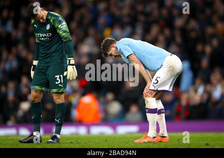 Manchester City goalkeeper Ederson (left) and John Stones appears dejected after his side score an own goal Stock Photo