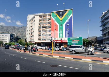 South African flag painted on tower block of flats above Mcdonalds fast food restaurant at the end of Long Street Cape Town South Africa. Stock Photo