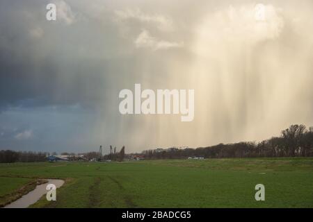 Hail and snow fall streaks of a wintry shower over the dutch landscape Stock Photo