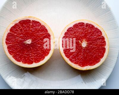 A sliced grapefruit on a plate Stock Photo