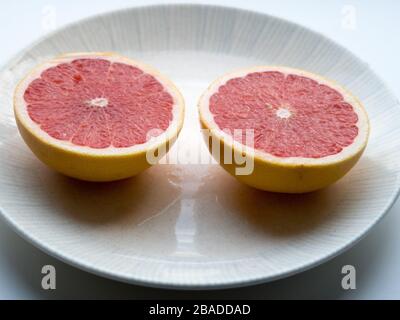 A sliced grapefruit on a plate Stock Photo