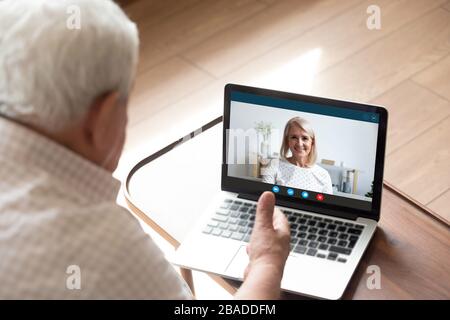 Happy middle aged woman chatting with older father husband online. Stock Photo